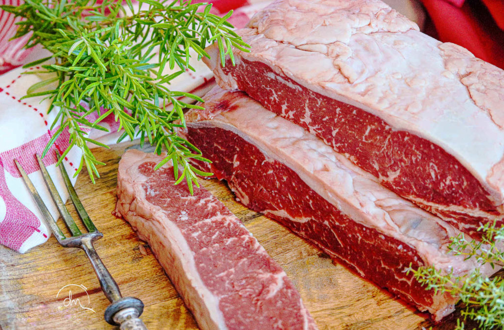 Pièce crue de Faux-Filet Angus persillée, avec un brin de romarin
