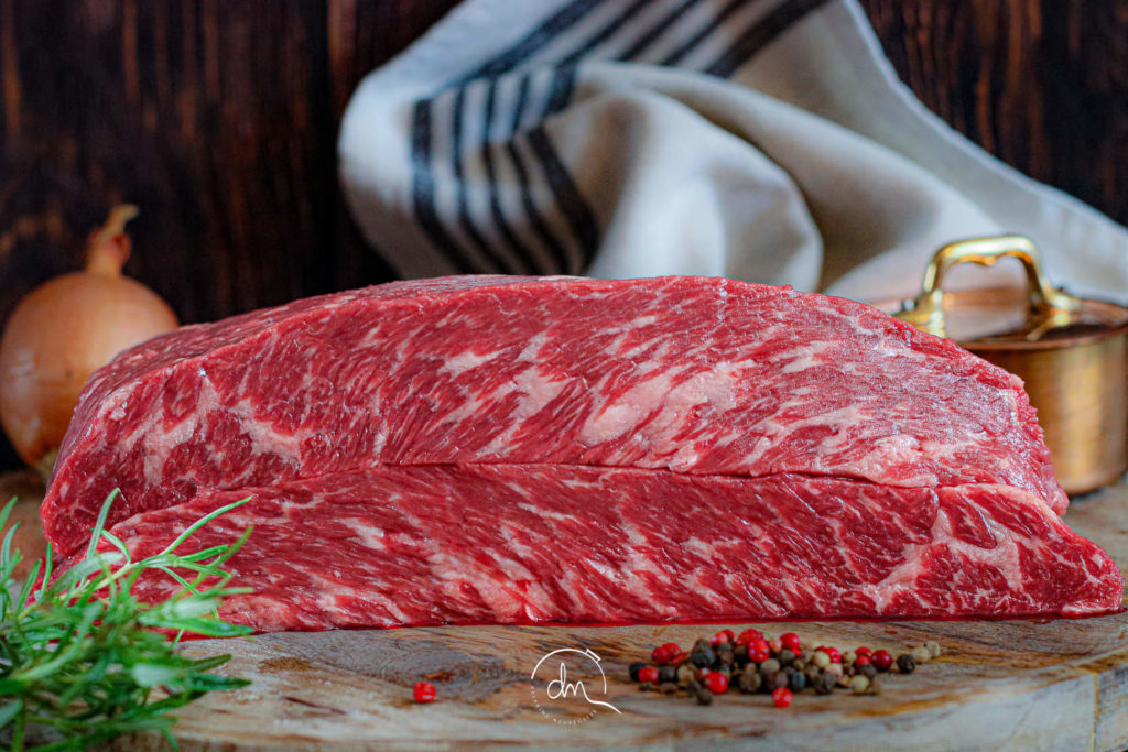 Pièce crue de Chuck Flap Angus posée sur une planche en bois