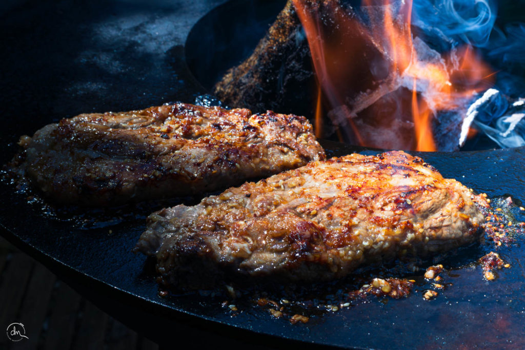 Côtes d'Échine de Porc Noir de Bigorre AOP en cuisson au brasero plancha, flamme vive