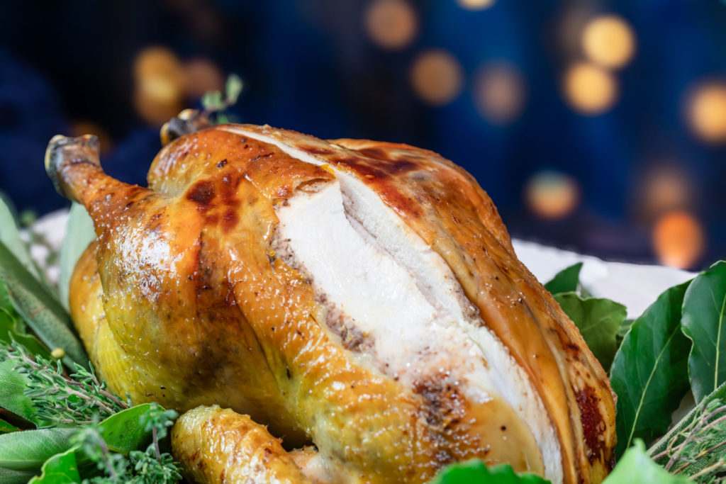 Poularde de Bresse AOP rôtie découpée, gros plan sur la chair moelleuse et la peau croustillante