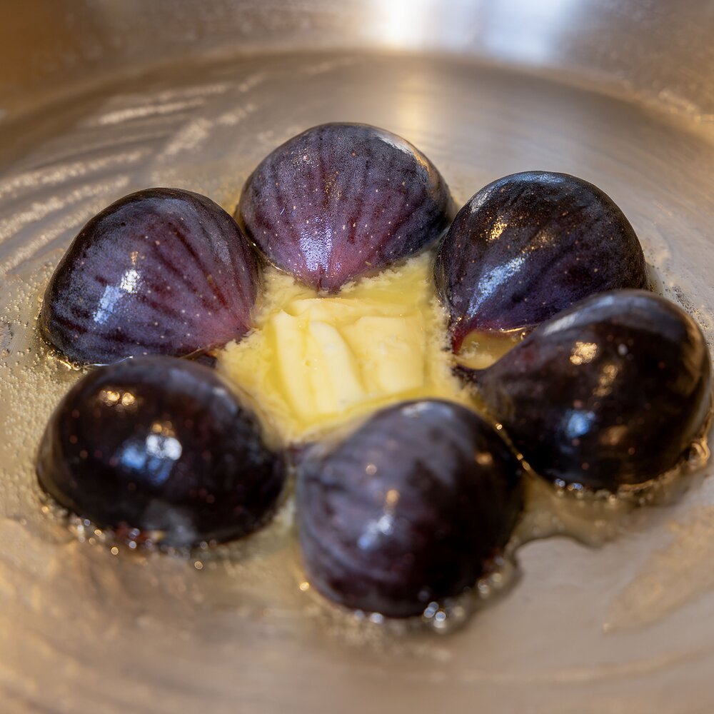 Figues entières coupées en deux en cours de cuisson dans la poêle avec le beurre